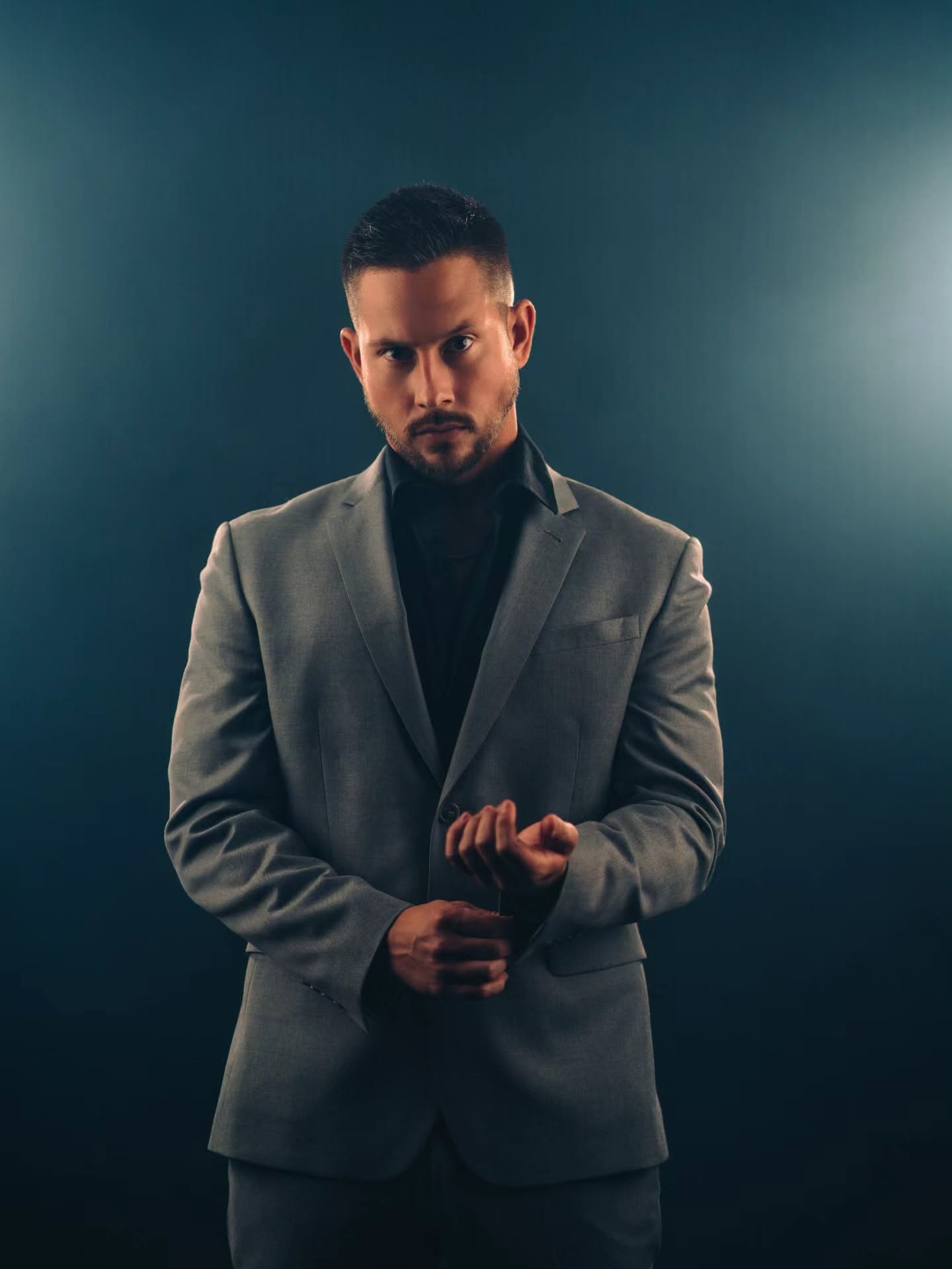 James Dean Sturdivant (JD) wearing a gray suit against a dark backdrop